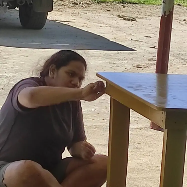 A lady worker from PWD fixing up the varnishing on one of the tables.