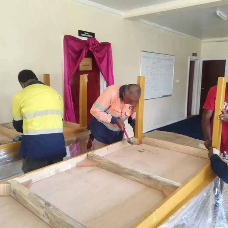 PWD workers drill and fasten the table parts together.