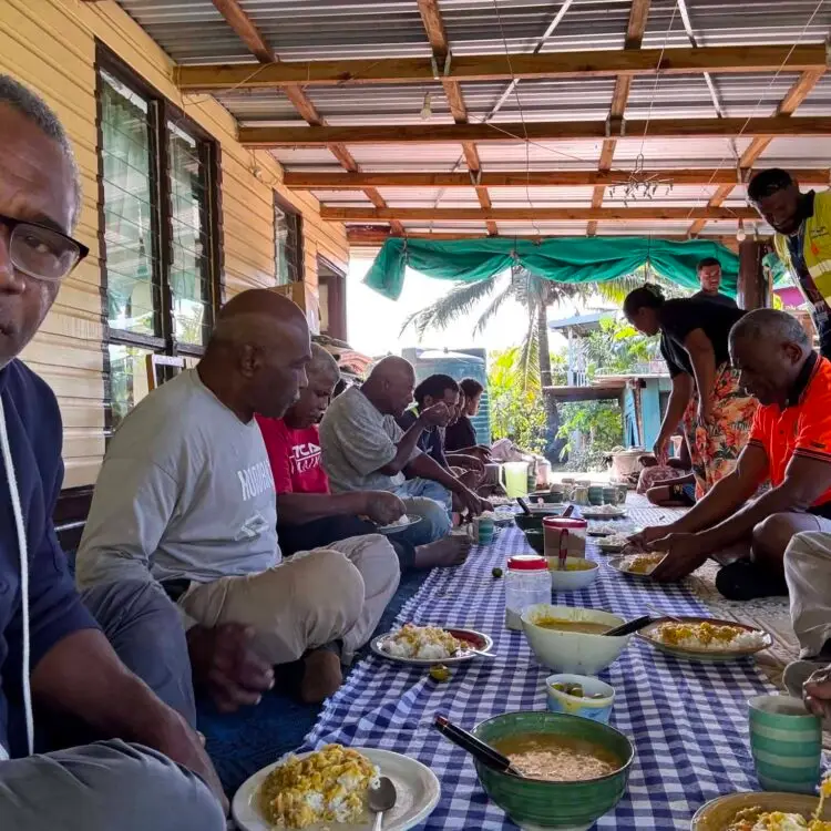 Seated nicely at the lunch spread. Rice, curry corned beef and dhal with cassava and dalo prepared in front of them.